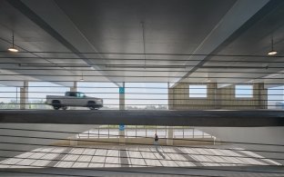 View of the parking deck in between two levels with a car driving on it