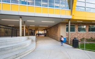 A student enters school through a long covered walkway.