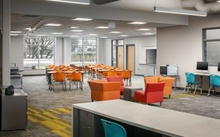 A common learning space with brightly colored chairs and tables.