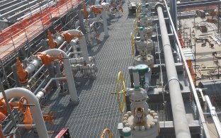 Outdoor image of thick pipping and a platform for people to walk around
