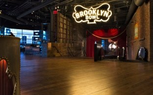 An open floor area with a sign reading "Brooklyn Bowl"