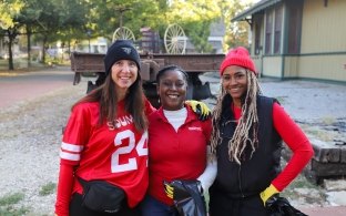 Three people standing and smiling at a volunteer event.