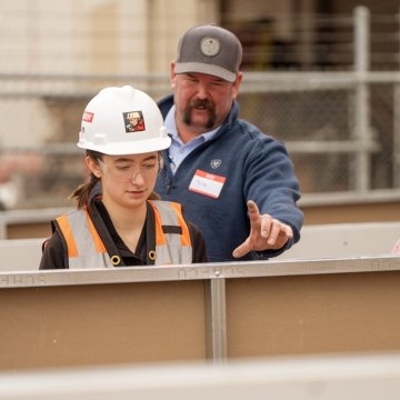Two people learning from someone else during a Construction 101 event.