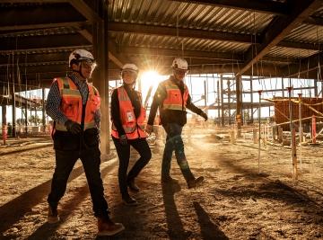 Three people walking a jobsite.