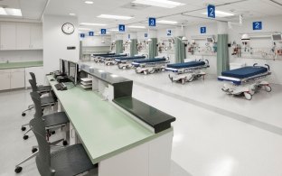 Indoor image of the nurses station and rows of beds with cloth dividers