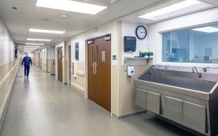View of a hallway with a sink at the forefront of the photo.