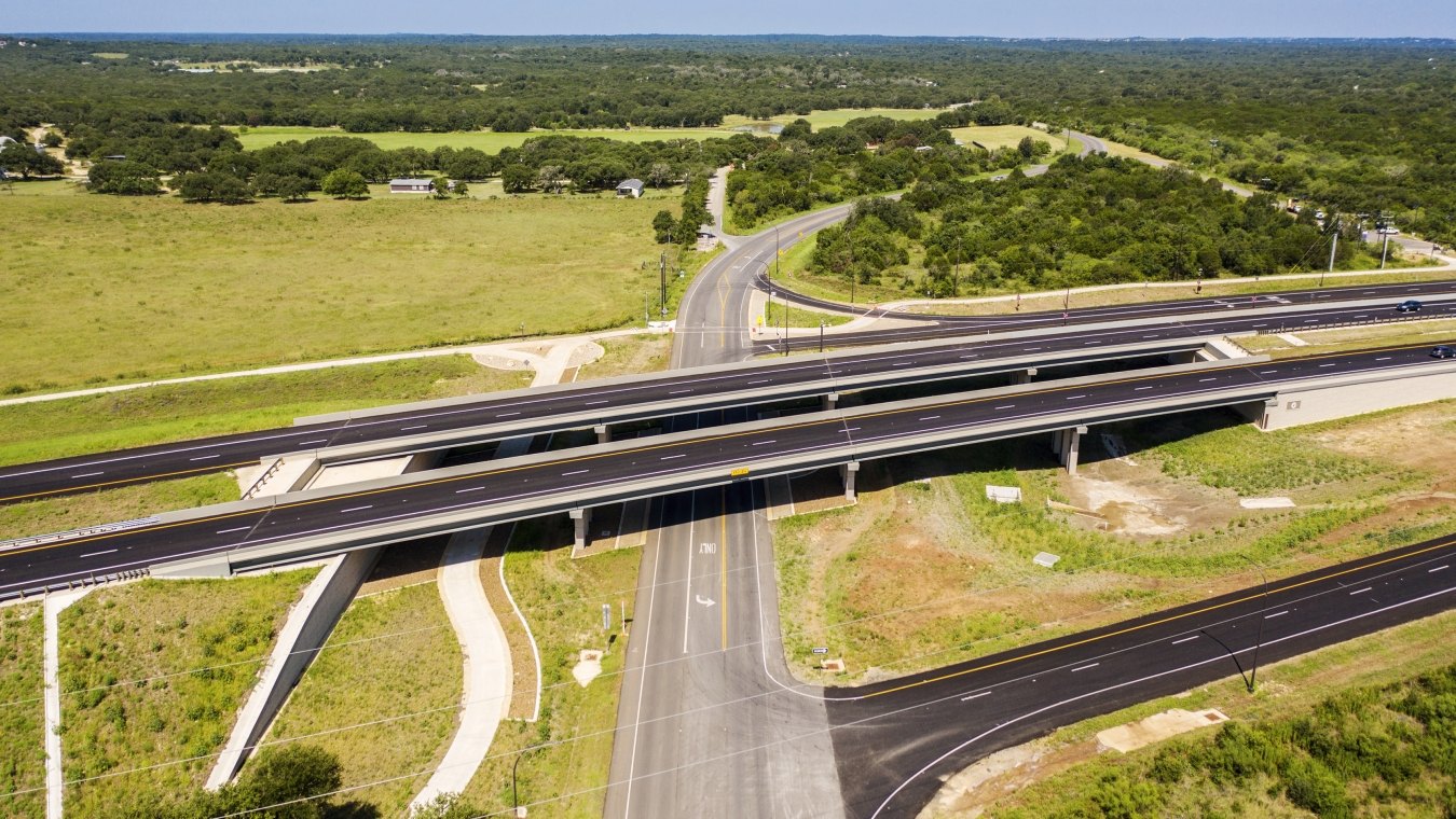 Highway with lots of greenery around and road going under
