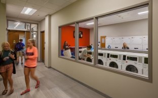 Students utilizing a laundry facility inside the housing facility.