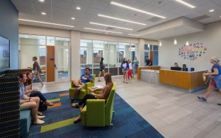 A lobby area with a receptionists' desk and lounge chairs
