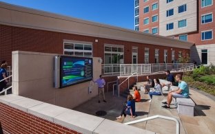 People sitting outside of the housing facility