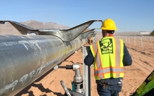 Solar workers tackle a metal installation at the Arrow Canyon Solar project to start 2022.