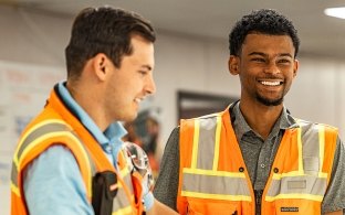 Two people talking while wearing safety vests