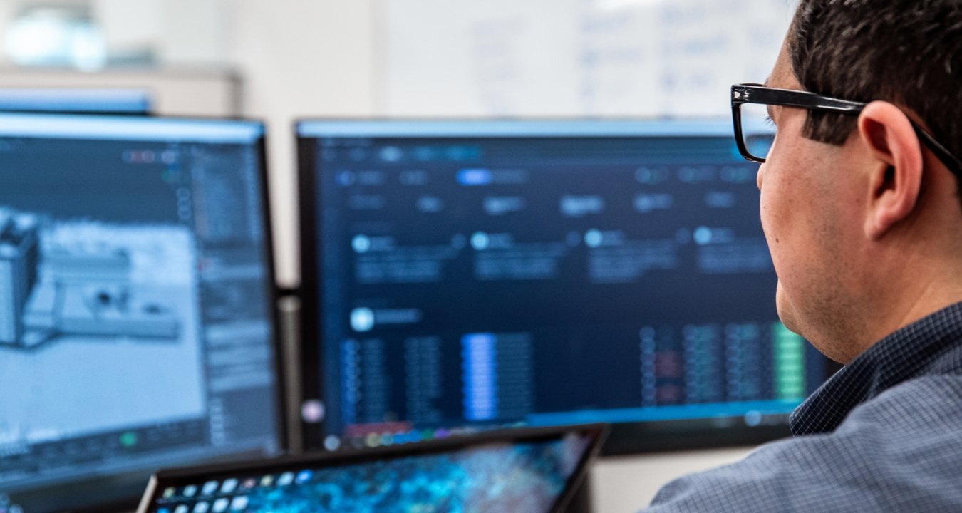 man sitting at his desk looking at a computer