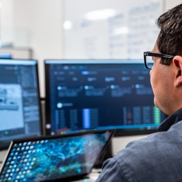 man sitting at his desk looking at a computer