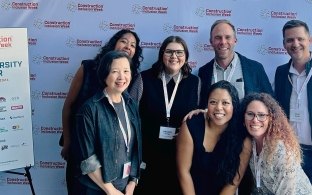 Group of people posing in front of a Construction Inclusion Week banner.