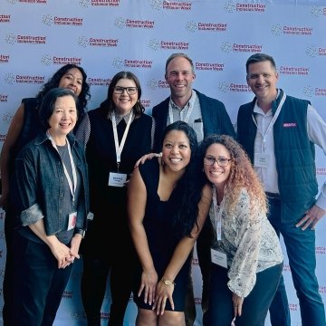 Group of people posing in front of a Construction Inclusion Week banner.
