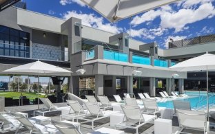 A pool area with lots of lounge chairs