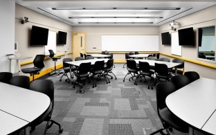 Classroom with tables and groups of chairs.