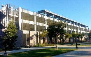A view of the Westminster PD parking structure from a tree-lined walkway.